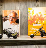 Aesthetic bookshelf with poetry books and metal motorcycle miniatures.