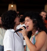 karaoke: a woman singing into a microphone while a man is holding a microphone