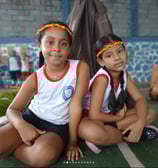 Duas alunas educação infantil centro educacional Florescer sentadas na quadra esportiva