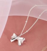 a silver bow tie necklace with a silver bow