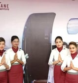 a group of women in uniform standing in front of a plane