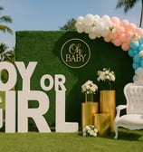 Elegant outdoor gender reveal event setup with pastel balloon decorations, floral arrangements, and luxury backdrop by Las Ca