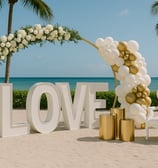 Luxury outdoor event decor featuring giant illuminated letters, elegant floral arrangements, and stylish setup by Las Carolin