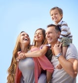 uma família de três sorrindo e rindo juntos
