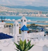 Vue panoramique de Tanger, Maroc, montrant la médina historique aux bâtiments blancs et le port animé, reflétant la fusion de