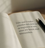 Minimalistische Szene mit Eukalyptuszweig in Glasvase am Fensterbrett und Zitat über inneren Wohlsta
