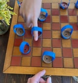 uma pessoa jogando damas em uma placa de madeira