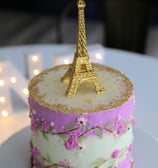 a cake with a gold eiffel tower in the background