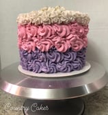 a cake with a pink and purple cake with white and pink flowers