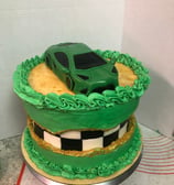 a cake with a green car on top of a cake