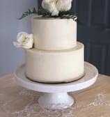 a cake with white frosting and white roses