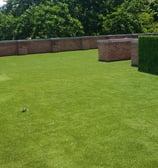Pasto sintético verde instalado en jardín residencial en Guadalajara