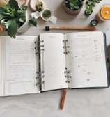 a notebook with a pen and a pencil and a cup of coffee