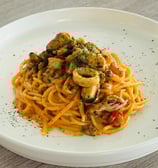 Italian seafood spaghetti served with mussels, squid, and herbs in a creamy tomato sauce