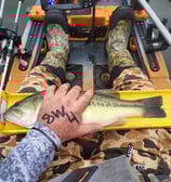 a person holding a fish on a kayak