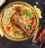 a chicken dum biryani rice dish with a chicken and vegetables