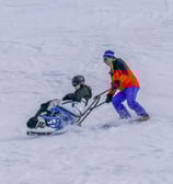 Sauveteur qui descend une skieuse blessée