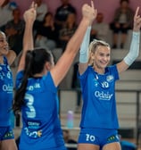Trois joueuses qui lèvent les bras en souriant pour fêter un point