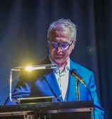 Un homme derrière un pupitre qui fait un discours