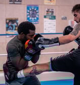 Boxeur qui met un coup de pied à son adversaire qui se défend