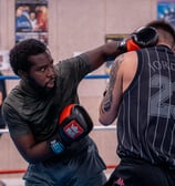 Boxeur qui envoie un coup de poing dans le visage de son adversaire
