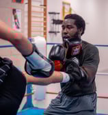 Boxeur qui se défend d'un coup de pied dans le ventre