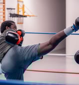 Boxeur qui essaye de mettre un coup de pieds dans la tête de son adversaire