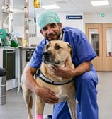 Le Dr Cyrill Poncet qui fait une photo avec un chien avant son opération