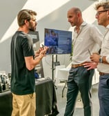 Groupe de personnes qui discutent autour d'un stand de produits de beauté pour les hommes