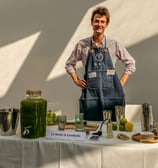 Personne qui pose derrière son stand qui propose des cocktails