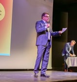 Personne qui parle sur scène avec un micro