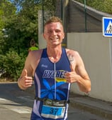 Coureur qui court en souriant et en levant les pouces