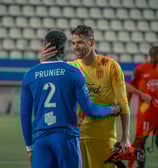 Gardien de Martigues et défenseur de Versailles qui font une accolade après le match