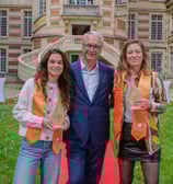 Un homme et deux femmes qui posent avec un trophée devant la mairie de Versailles