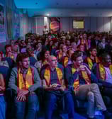 Les participants à la conférence sont assis dans la salle de spectacle et regardent la scène