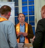 Trois hommes qui discutent autour d'un stand