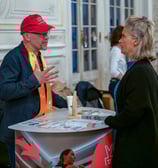 Un lauréat et une femme qui discutent de chaque côté d'un stand