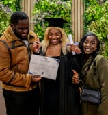 Une étudiante qui pose avec sa famille et son diplôme dans les mains