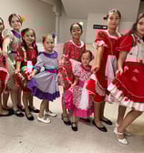 a group of young girls in dresses