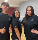 three people standing in a room