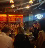 a group of people standing around a bar in Riga
