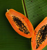 sliced papaya on green banana leaf