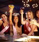 Bride-to-be and friends raising drinks during a fun-filled bachelorette night out on Fremont Street in Las Vegas.