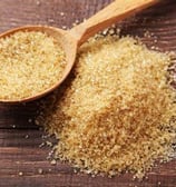 a spoon full of brown sugar on a wooden spoon hamer candy