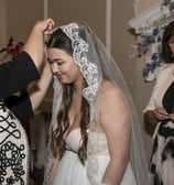 Hertfordshire Bride getting her veil pinned by the hairdresser, officiant smiling in the background.