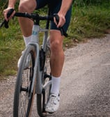a man riding a bicycle on a gravel road
