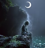 Mermaid sitting on a rock under a crescent moon