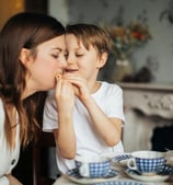 child with autism eating with his mom