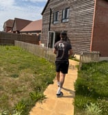 deanos removals worker carrying a box into a house in worcester