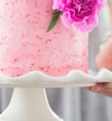 a woman holding a cake with candles and flowers.Tourism Consulting in England, Spain, Hungary